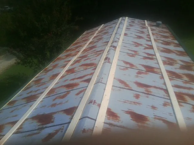 Rusted metal roof panels with new wood purlins before replacement — Storm Damage Roof Repair in King And Queen Court House by Roofing Brothers