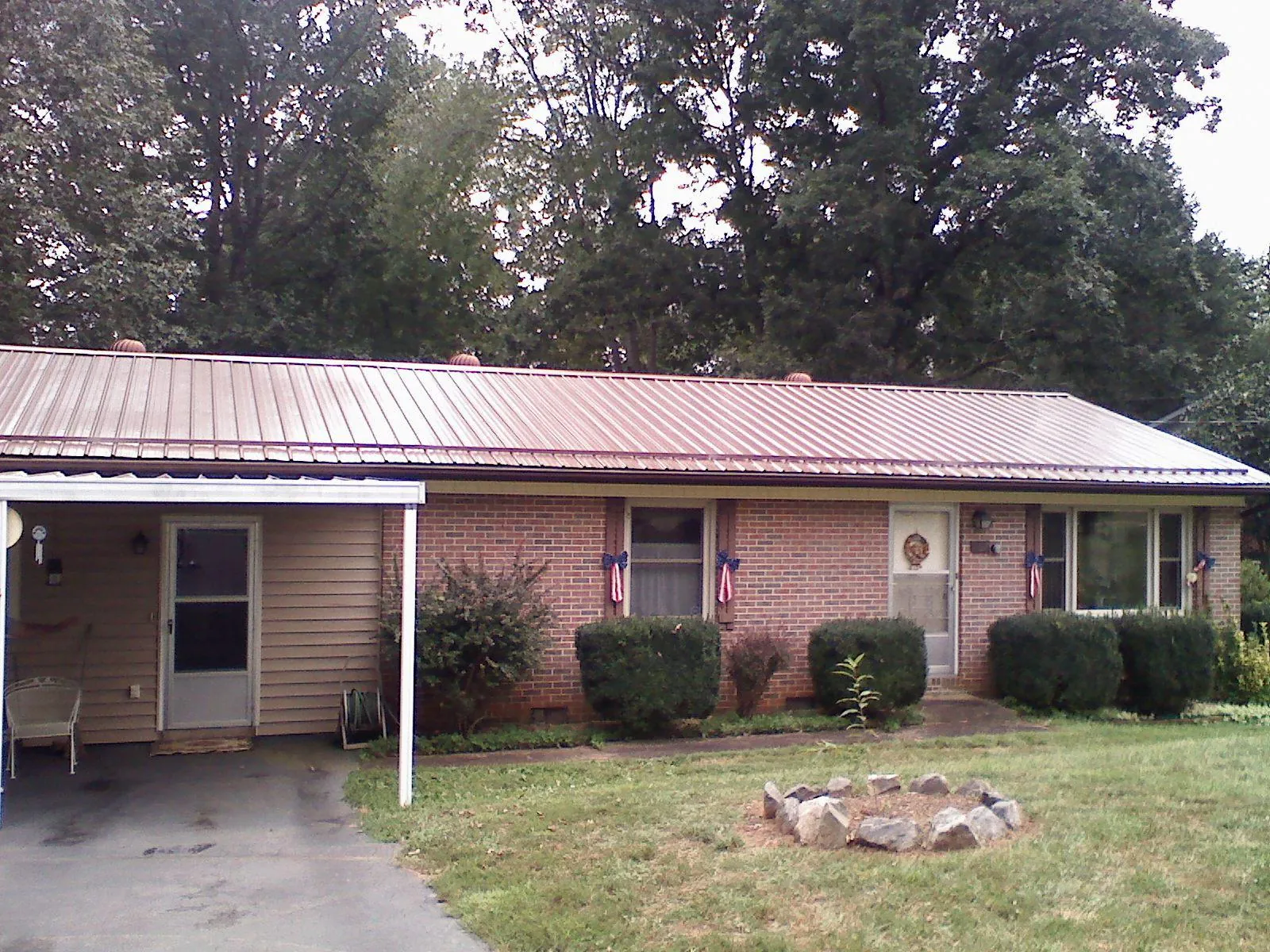 Bronze metal roof and carport on a brick ranch home — Roof Repair work by our crew in King And Queen Court House